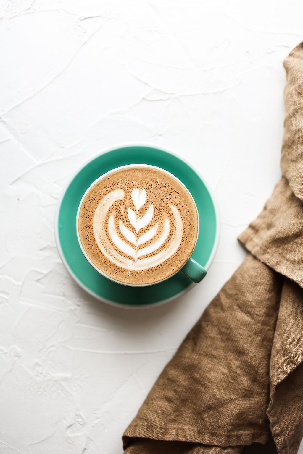 A picture of a coffee mug in bird eye's view showing a creative pattern formed with the milk