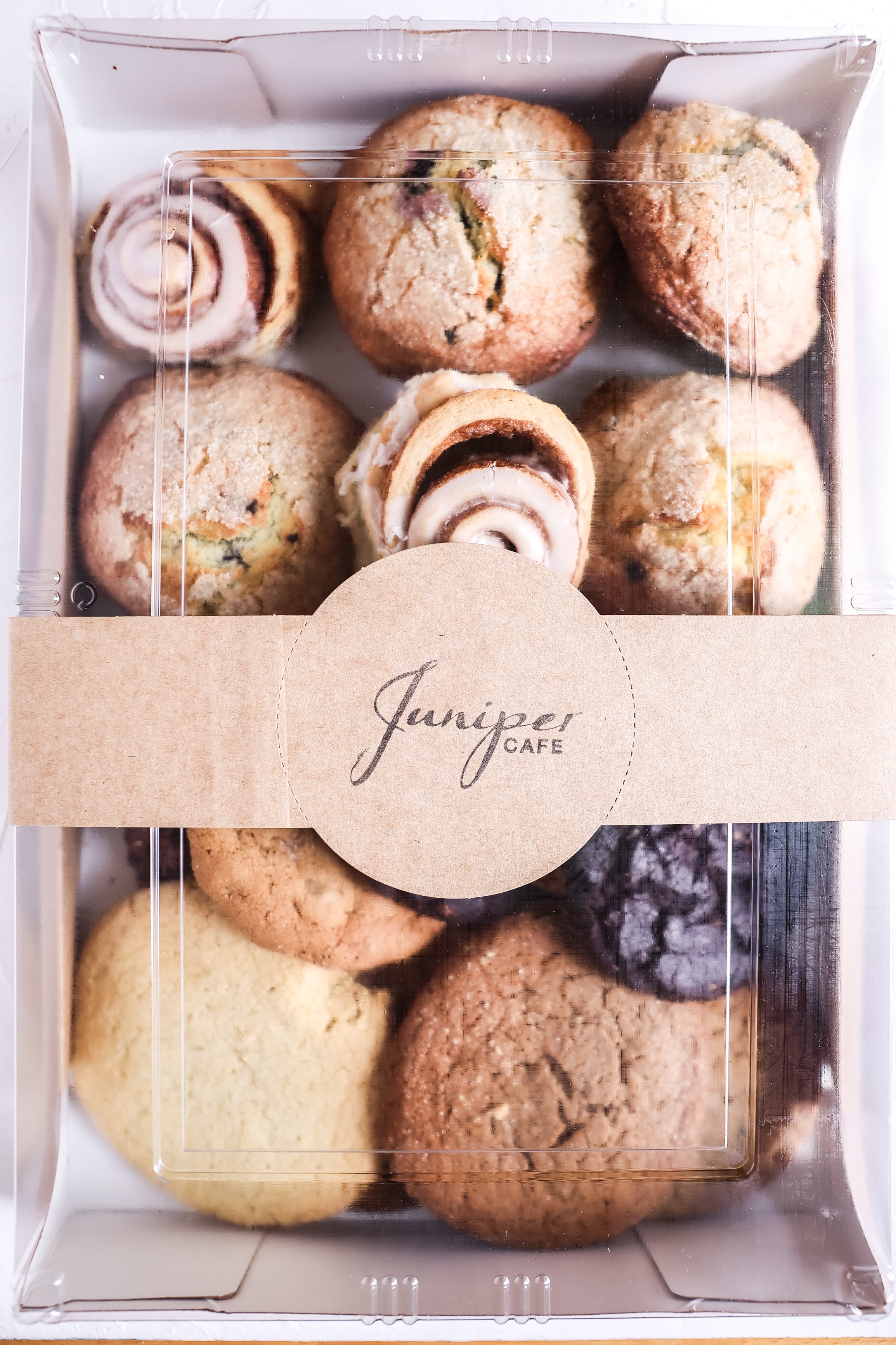 An image of a box containing a dozen different sweets such as cookies and muffins from Juniper Cafe.
