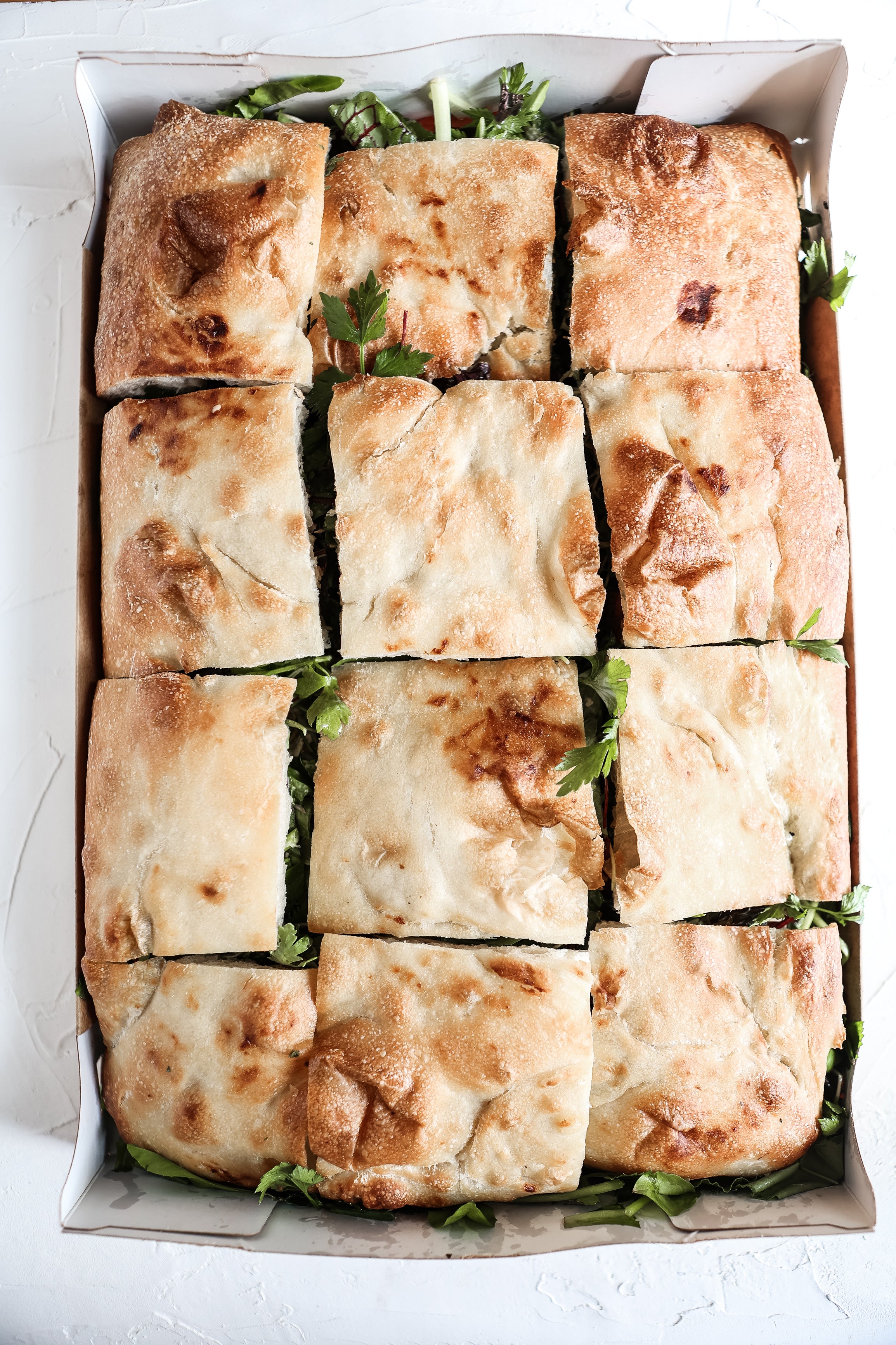 An image showing a 12 sandwich platter served in a box by Juniper Cafe.