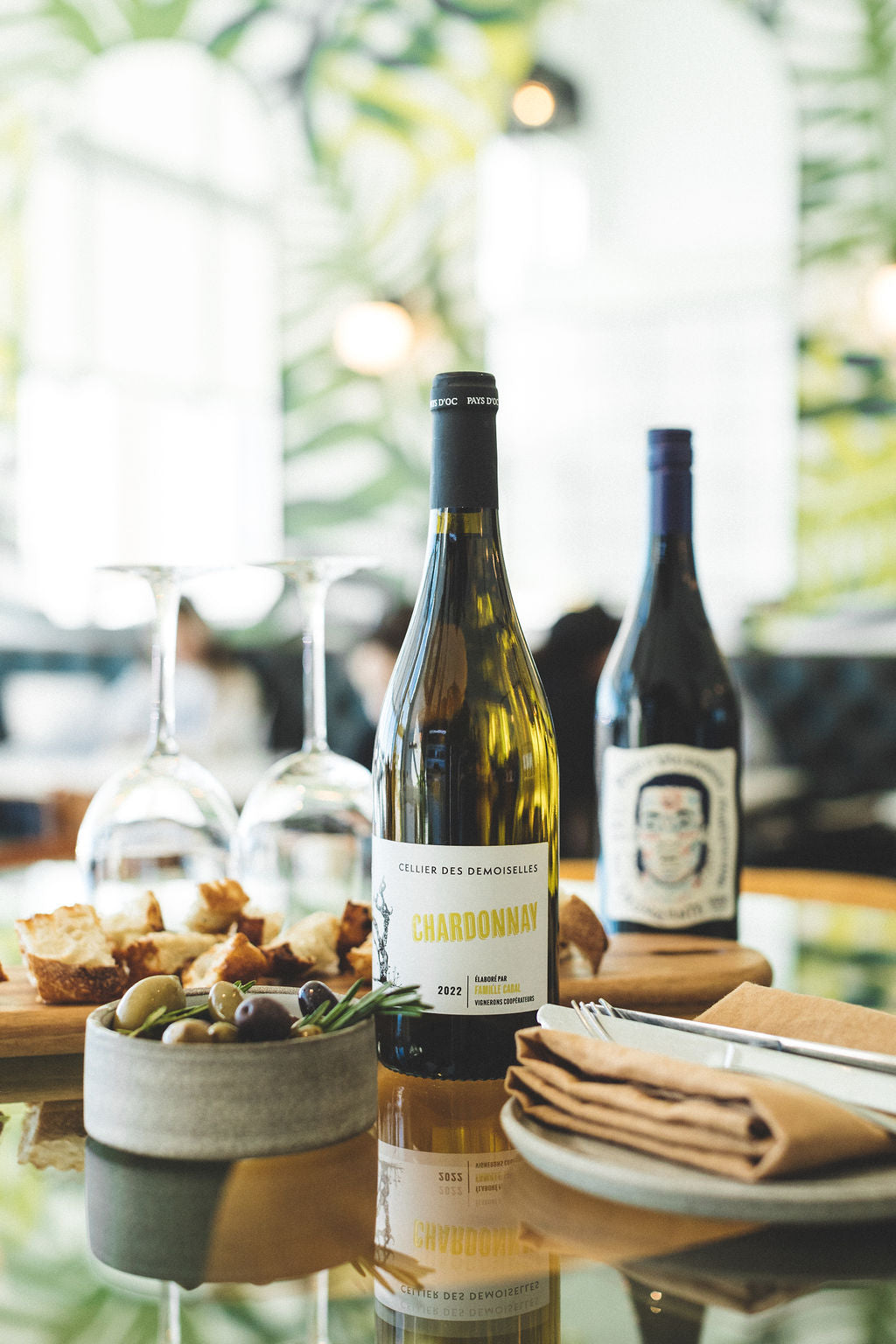 This image shows wine bottles served at a table for two, setting the mood for a romantic outing at Juniper Cafe.